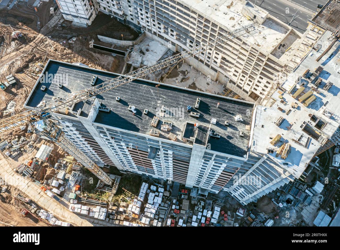 gru che lavora su un alto edificio residenziale in costruzione. foto aerea drone guardando verso il basso. Foto Stock