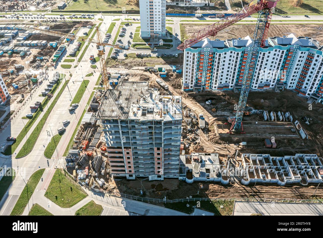 vista aerea di un grande cantiere con edifici residenziali in costruzione, gru, attrezzature e materiali da costruzione. Foto Stock