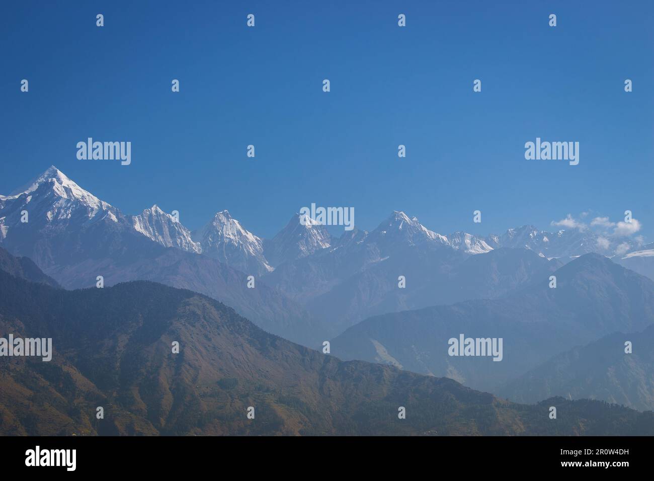 Bellissimo paesaggio himalayano con prospettiva nella foschia mattutina. Vette innevate e verdi montagne Himalaya. Himalaya natura. India paesaggio. Foto Stock