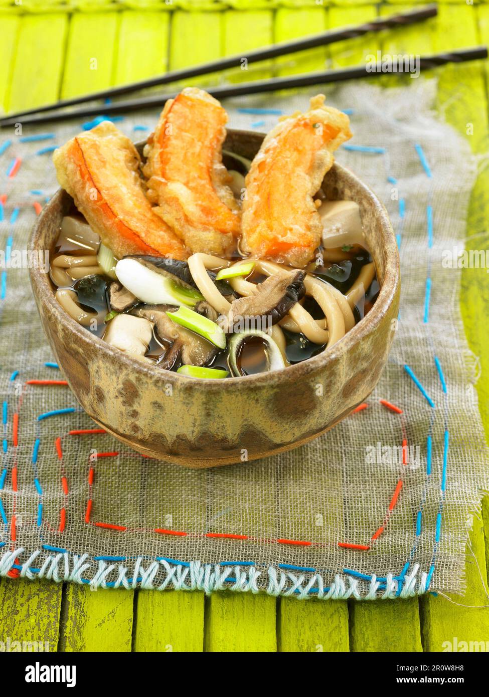 Udon pasta, shitake, tofu, e brodo di alghe con tempura Kabocha Foto Stock