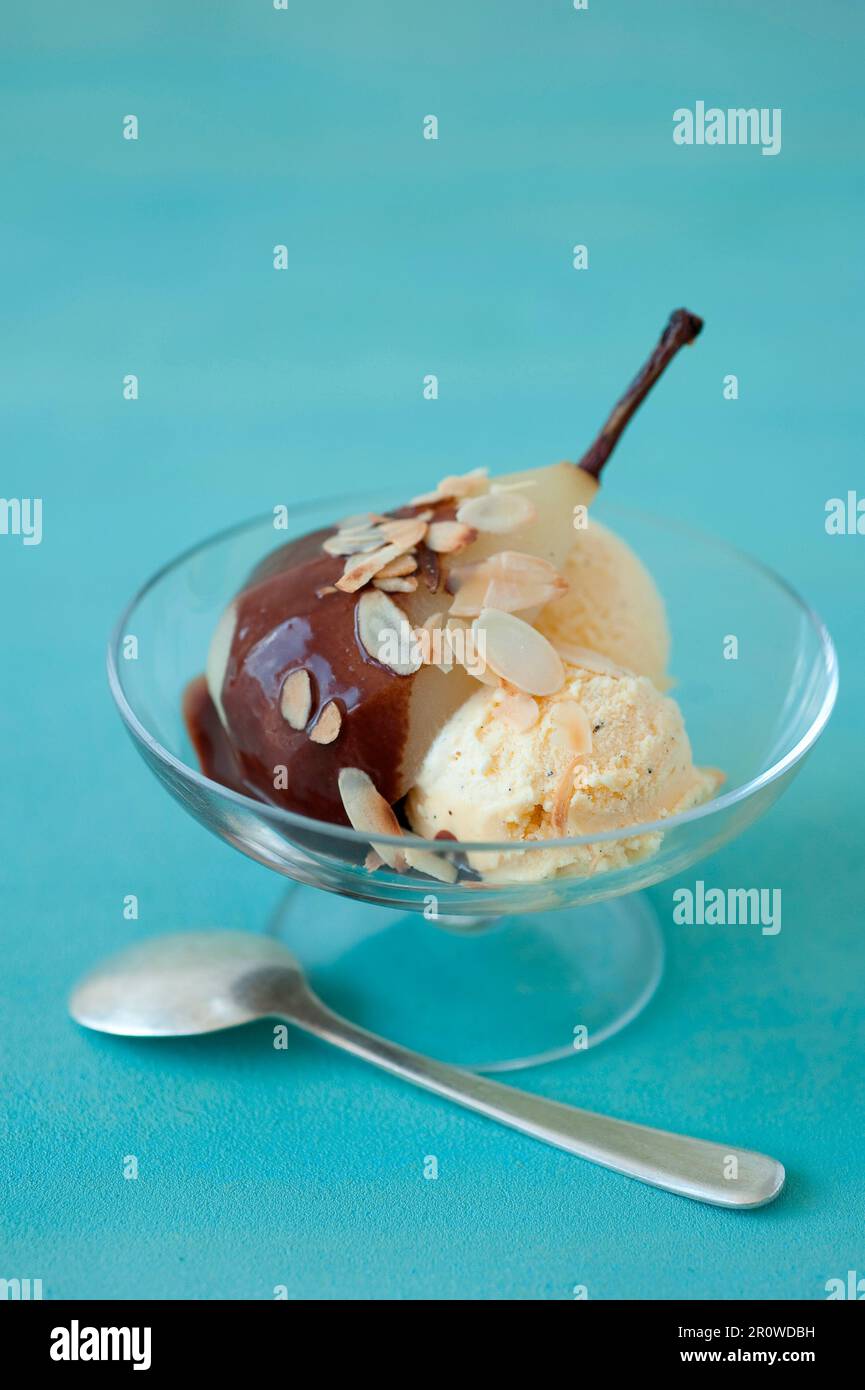 Pera stufata con salsa al cioccolato e gelato alla vaniglia Foto Stock