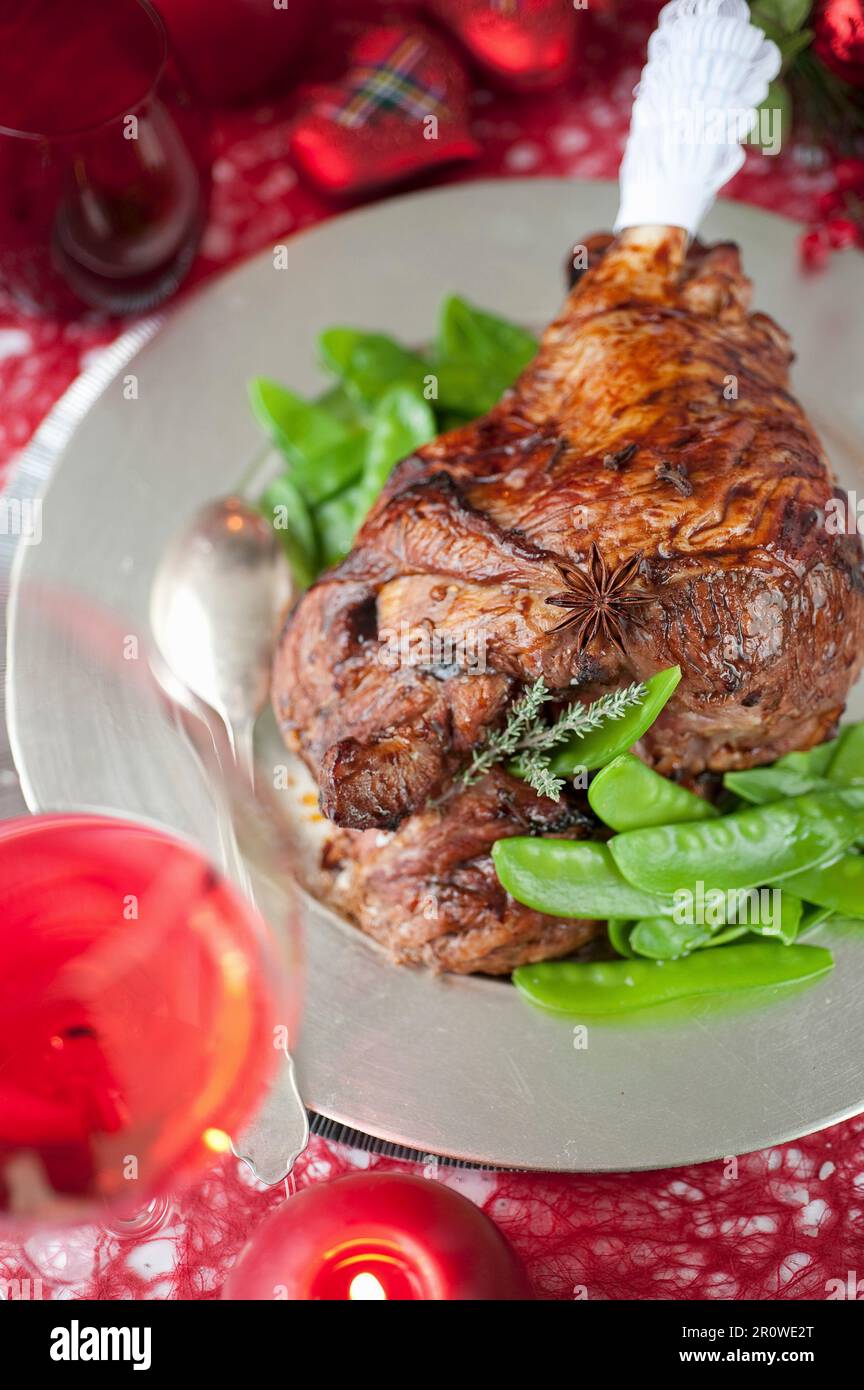 Coscia di agnello scozzese speziata con piselli allo zucchero Foto Stock