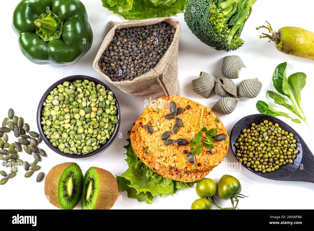 Polpettine di soia circondate da verdure verdi, frutta, legumi e semi Foto Stock
