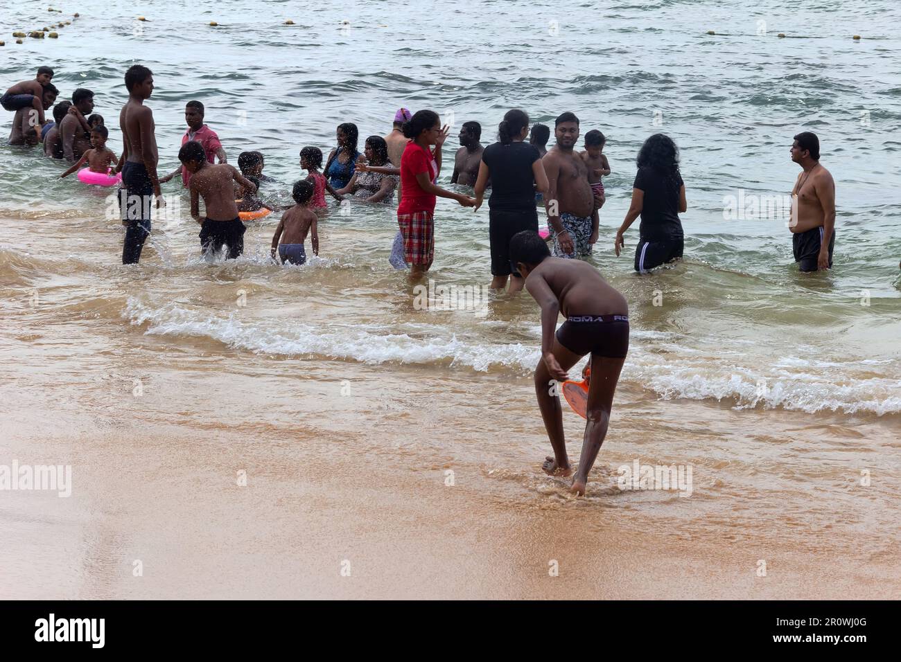 Sri Lanka, Hikkaduwa-11 dicembre 2019: Il giorno di partenza, singalese si sguanta in acque poco profonde. Le donne non togliere i loro vestiti esterni a causa di tradimento Foto Stock