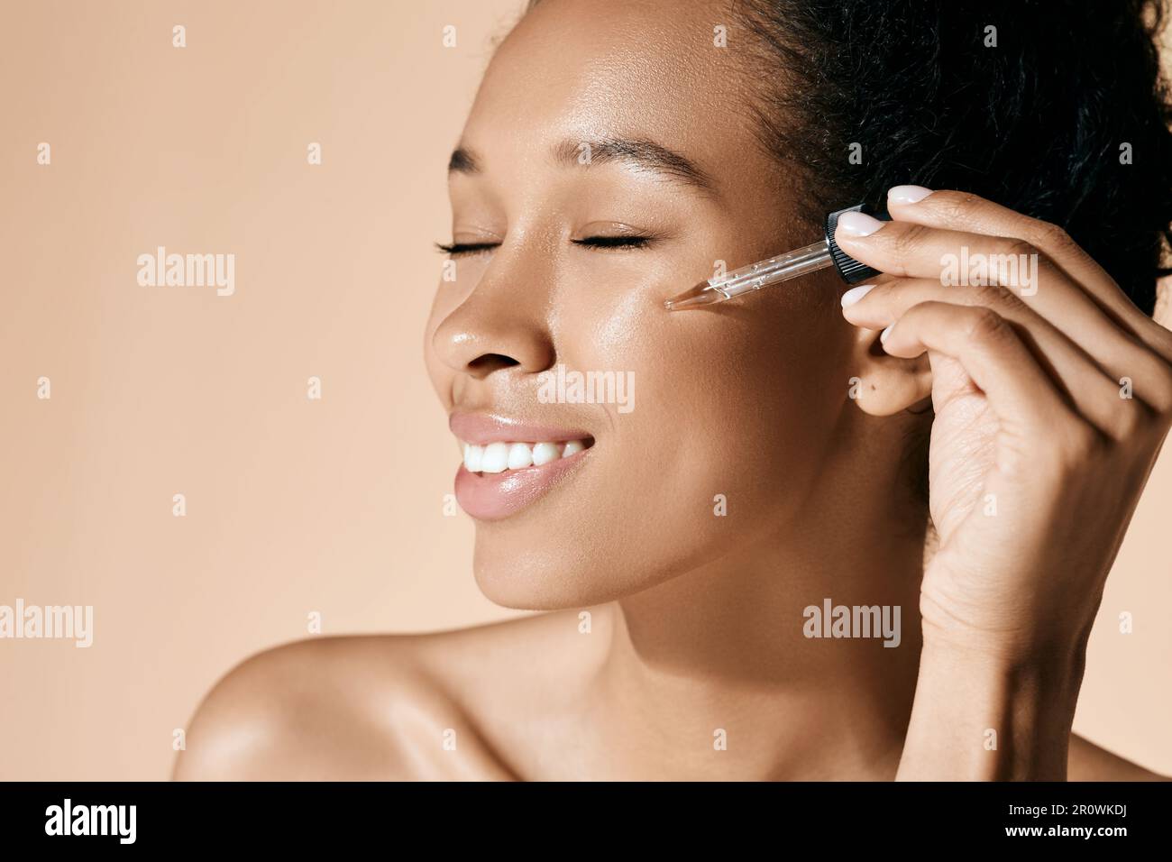 Bella donna che applica olio essenziale sul viso per una pelle idratata utilizzando un contagocce per pipette. cura della pelle del viso con olio e siero essenziali per il trattamento Foto Stock