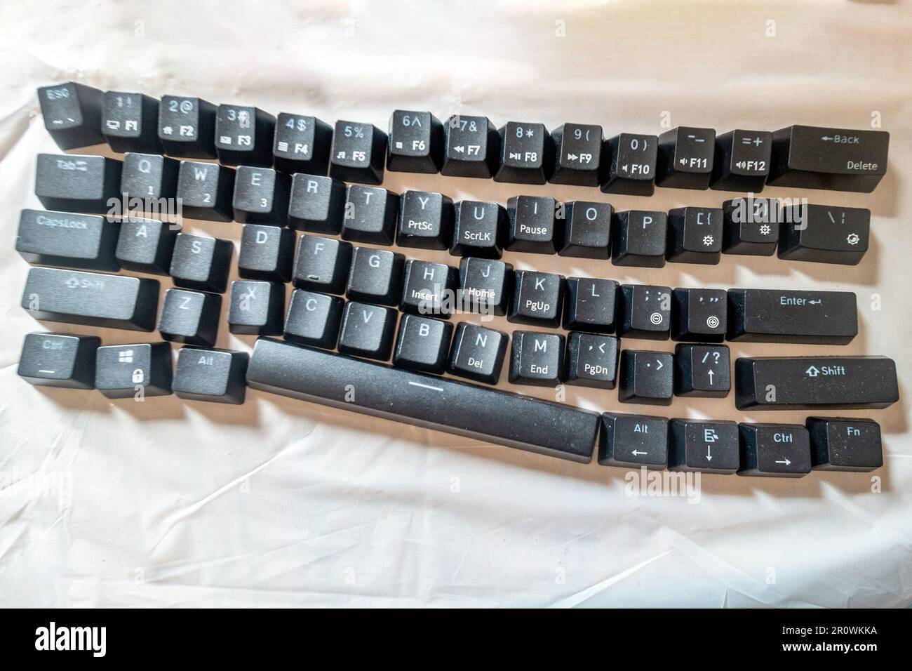 Le facciate dei pulsanti della tastiera di un computer sono state rimosse, pulite e disposte in ordine su un panno bianco. Foto Stock