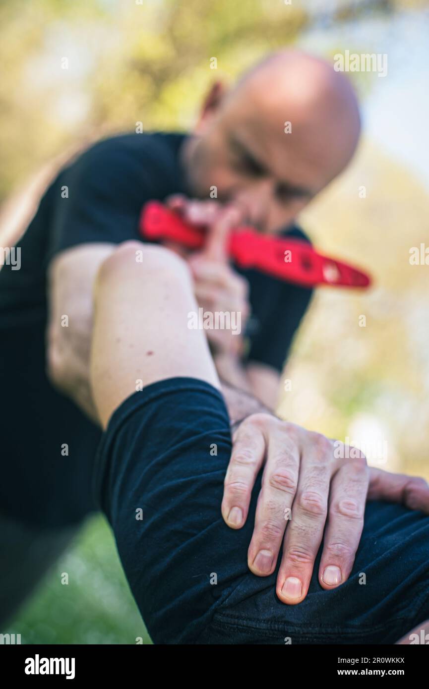 Attacco coltello auto-difesa. Tecniche di disarmo coltello attaccante. Arma disarma allenamento Foto Stock
