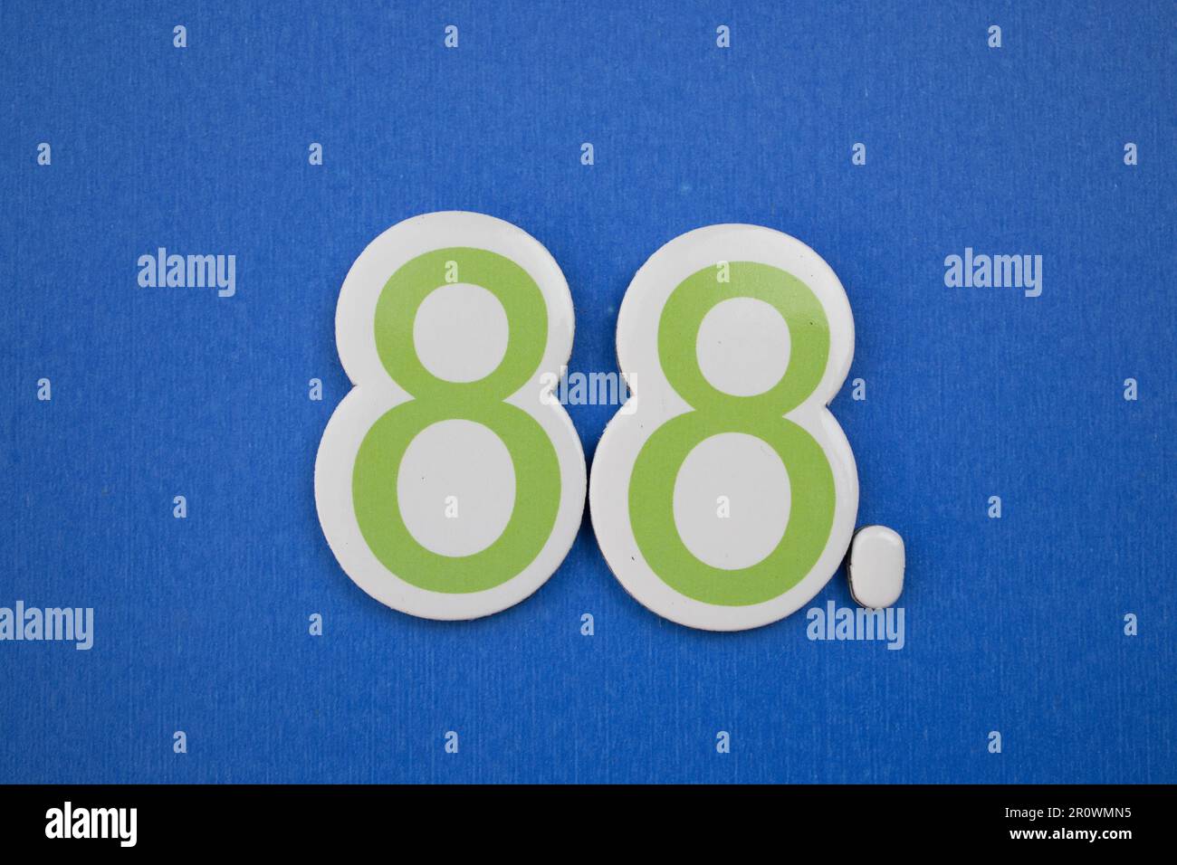 Il numero 88, posto su sfondo blu, fotografato dall'alto, di colore blu scuro e verde. Foto Stock