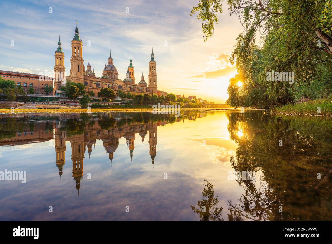 Zaragoza, Spagna. Vibrante paesaggio al tramonto lungo il fiume Ebro e la Basilica del Pilar Foto Stock