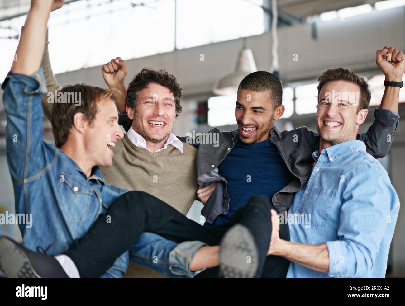 Più duro lavorate, più fortunati ottenete. un gruppo di colleghi maschili che festeggiano in un ufficio. Foto Stock Più duro lavorate, più fortunati ottenete. un gruppo di colleghi maschili che festeggiano in un ufficio. Foto Stock