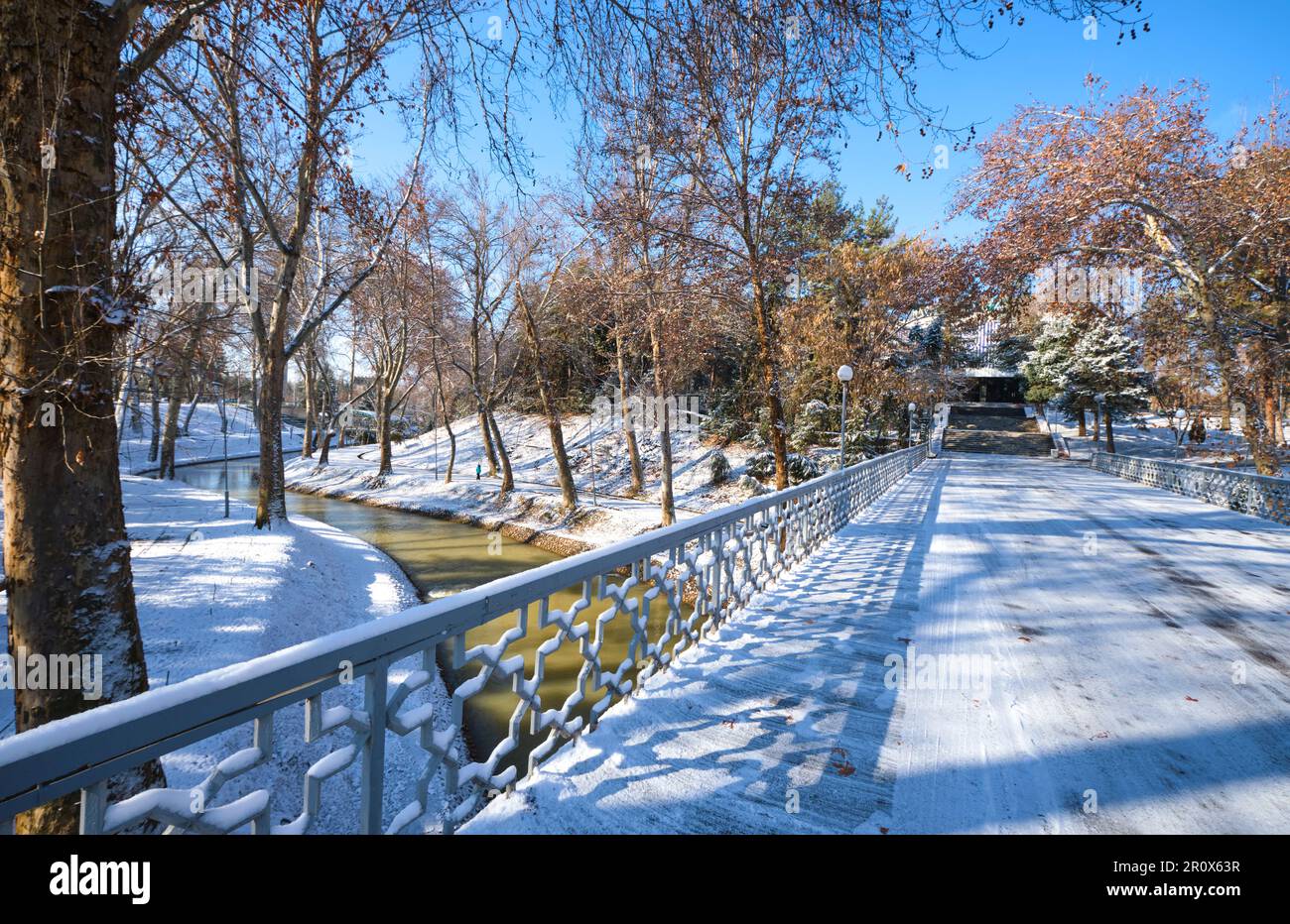 Vista sul piccolo ponte che conduce al Museo della Gloria Olimpica. Subito dopo una tempesta d'inverno lasciò una luce bianca spolverata di neve fresca. A Tashkent Foto Stock