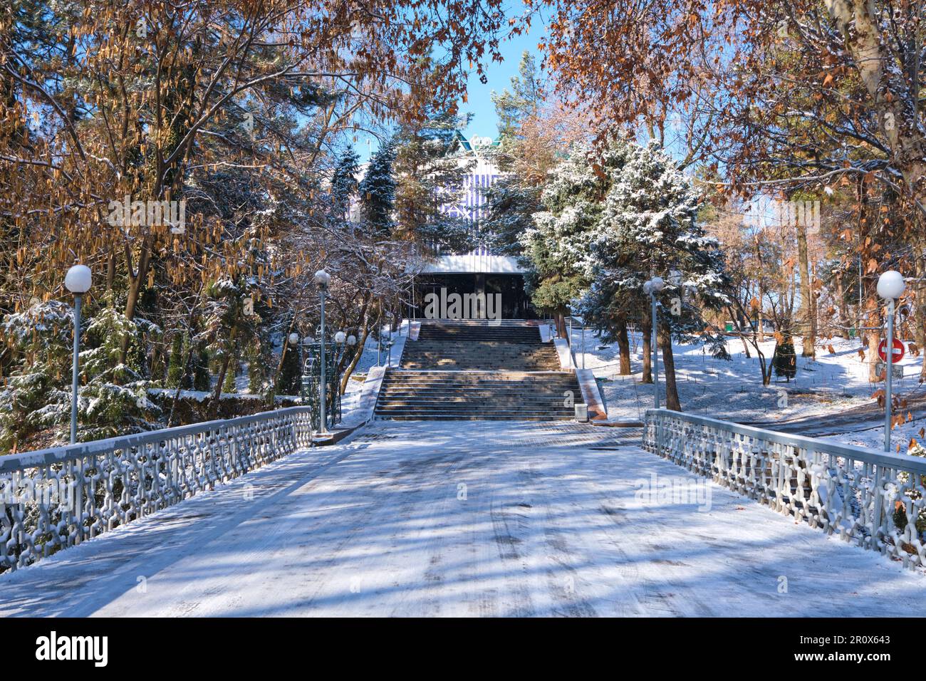Vista sul piccolo ponte che conduce al Museo della Gloria Olimpica. Subito dopo una tempesta d'inverno lasciò una luce bianca spolverata di neve fresca. A Tashkent Foto Stock