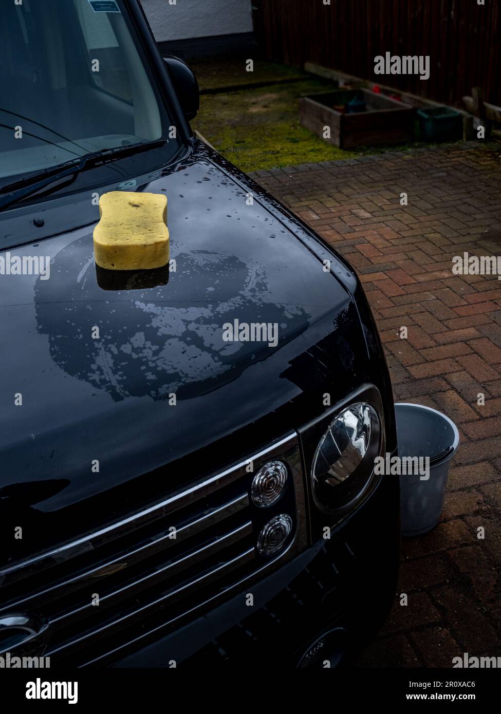 Lavare l'auto in vecchio modo utilizzando un secchio d'acqua e una spugna Foto Stock