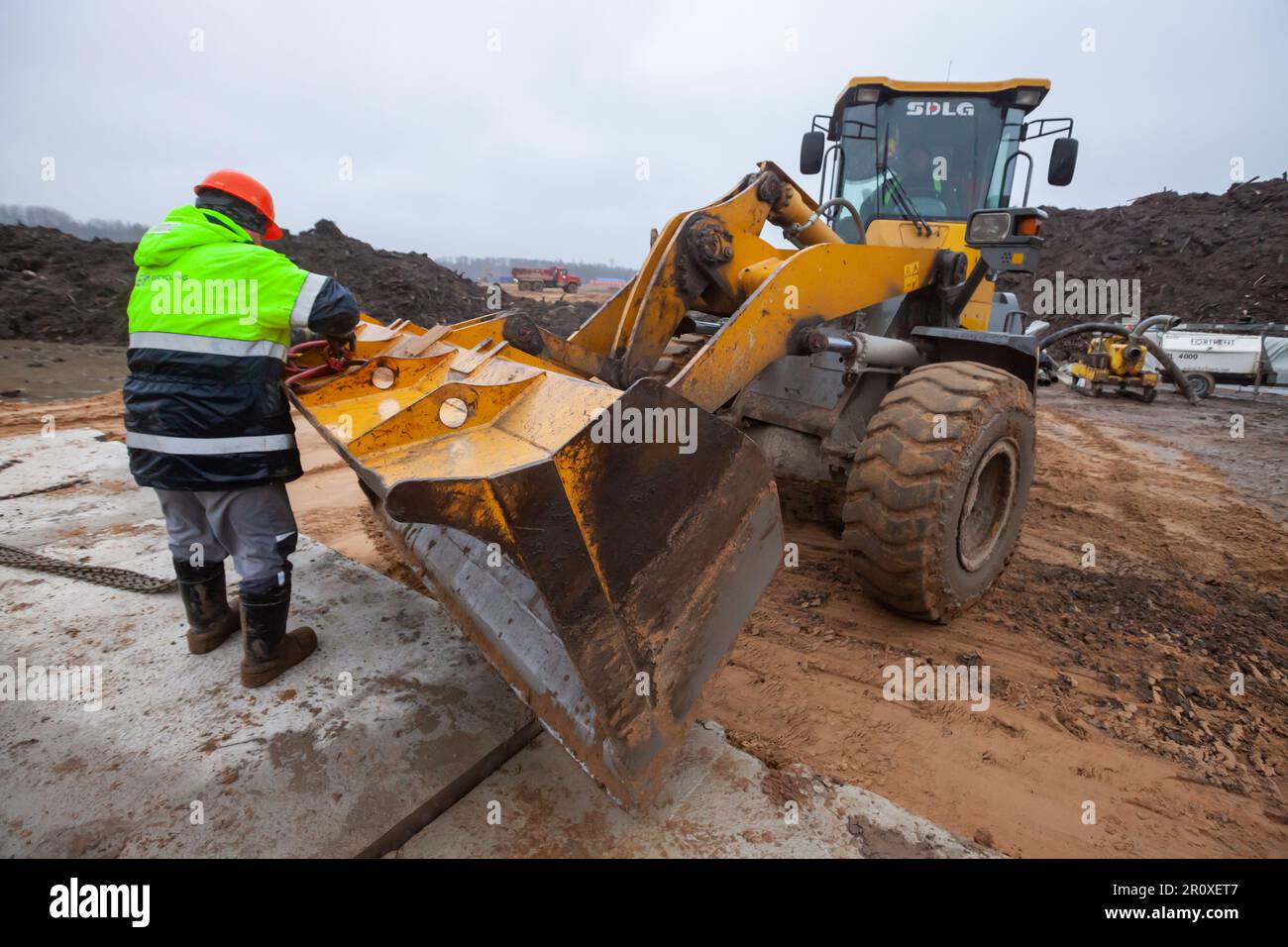 Ust-Luga, Leningrado oblast, Russia - 16 novembre 2021: Lavoratore e bulldozer SDLG Foto Stock