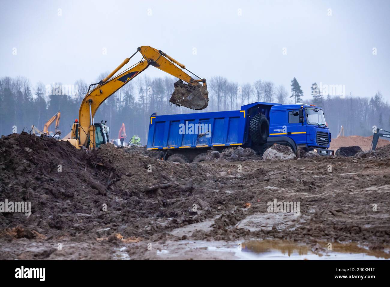 Ust-Luga, Leningrado oblast, Russia - 16 novembre 2021: Groundwjrks, escavatore carica dumper Foto Stock