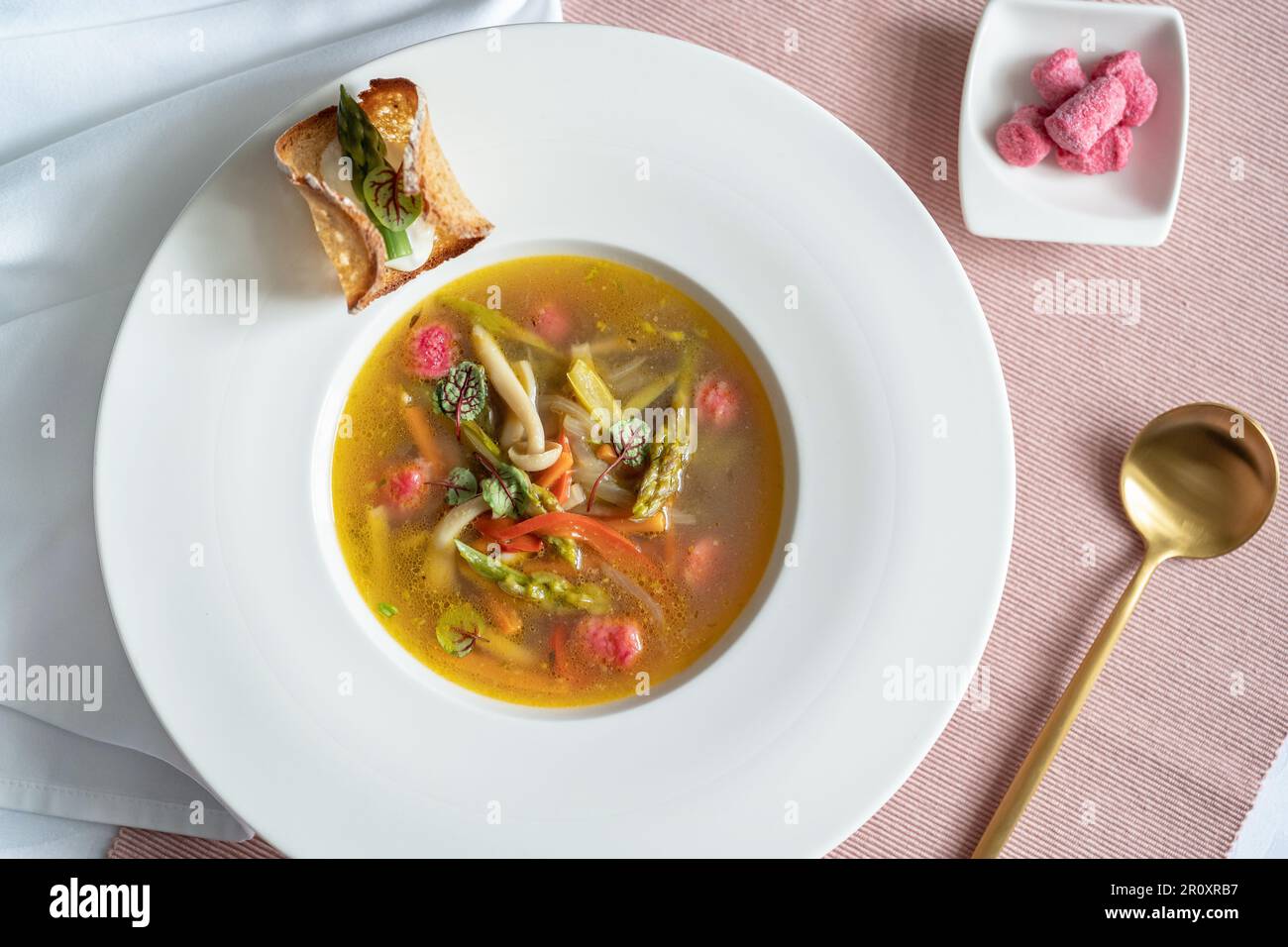 Vista dall'alto di una zuppa di verdure con gnocchi rosa (barbabietola) e variazione del pane. Tavolo da ristorante. Ristorante gourmet. Cibo vegetariano. Foto Stock