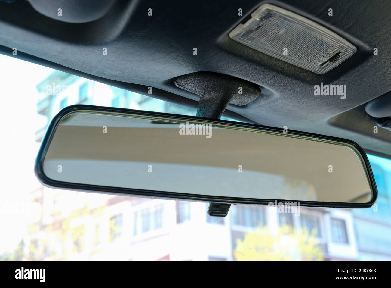 Primo piano specchietto retrovisore in vecchio stile classico all'interno dell'auto. Specchio nell'auto guardando indietro. Messa a fuoco selettiva dello specchio. Foto Stock