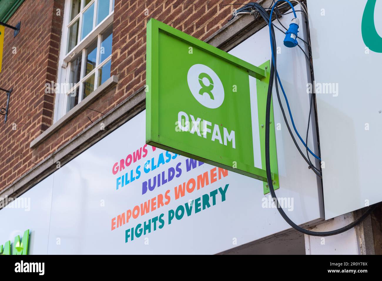 Cartelli sopra il negozio di beneficenza Oxfam a Tamworth, Staffordshire, Regno Unito Foto Stock