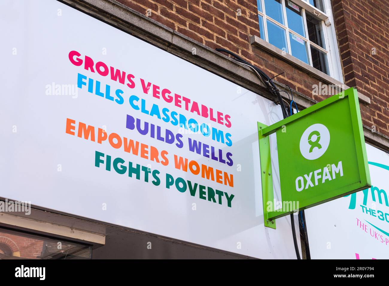 Cartelli sopra il negozio di beneficenza Oxfam a Tamworth, Staffordshire, Regno Unito Foto Stock