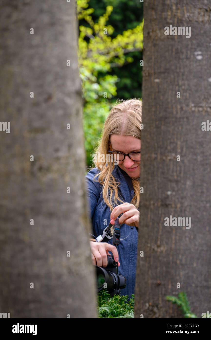 Una fotografa femminile nel suo elemento, catturando la bellezza della natura e dei paesaggi con la sua macchina fotografica, mostrando la sua creatività artistica e la sua abilità. Foto Stock