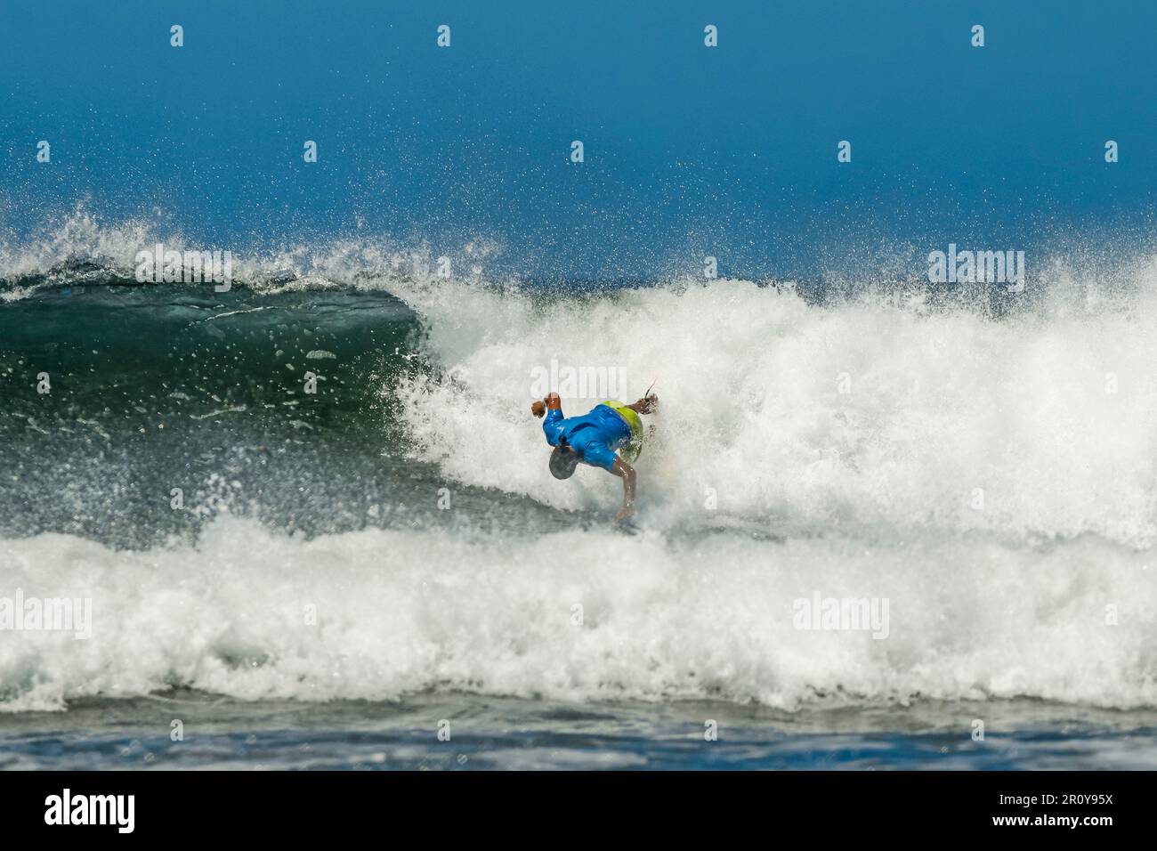 Surfista 'spazzare fuori' su un'onda di rottura in questa popolare spiaggia di surf e destinazione yoga. Playa Guiones, Nosara, Penisola di Nicoya, Guanacaste, Costa Rica Foto Stock