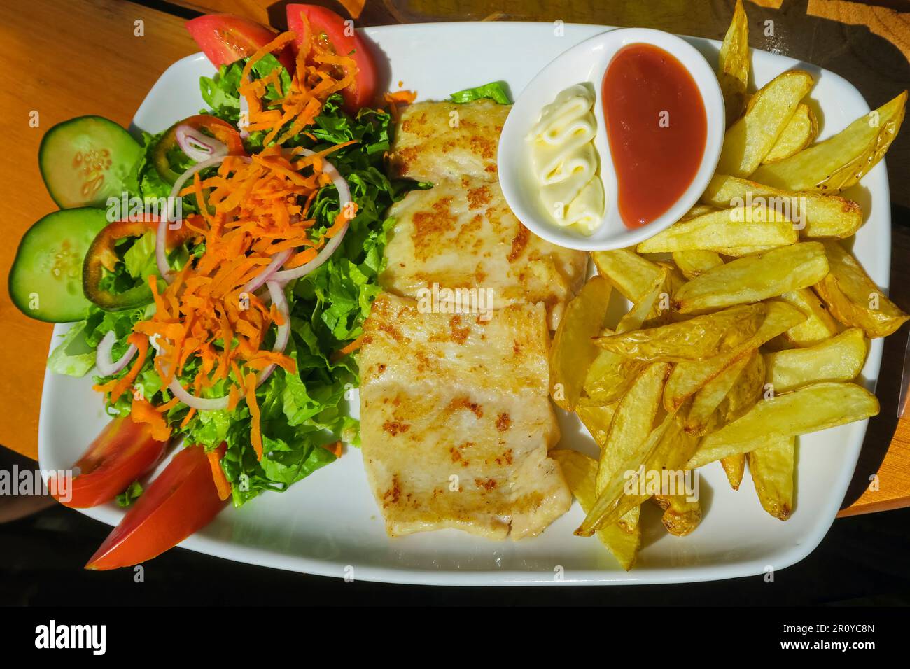 Mahi Mahi Pesce (aka Dorado) cotto 'a la planchaa' (alla griglia) con patatine fritte, insalata e salse, un piatto popolare Costa Rica: Guanacaste, Costa Rica Foto Stock