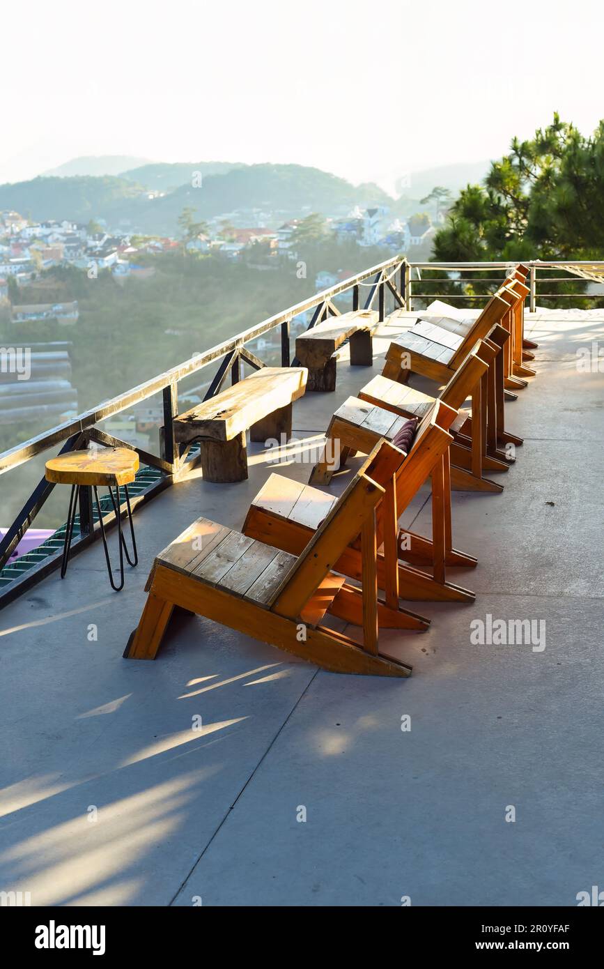 Sedie di legno senza persone contro il tramonto in montagna di da Lat in Vietnam Foto Stock