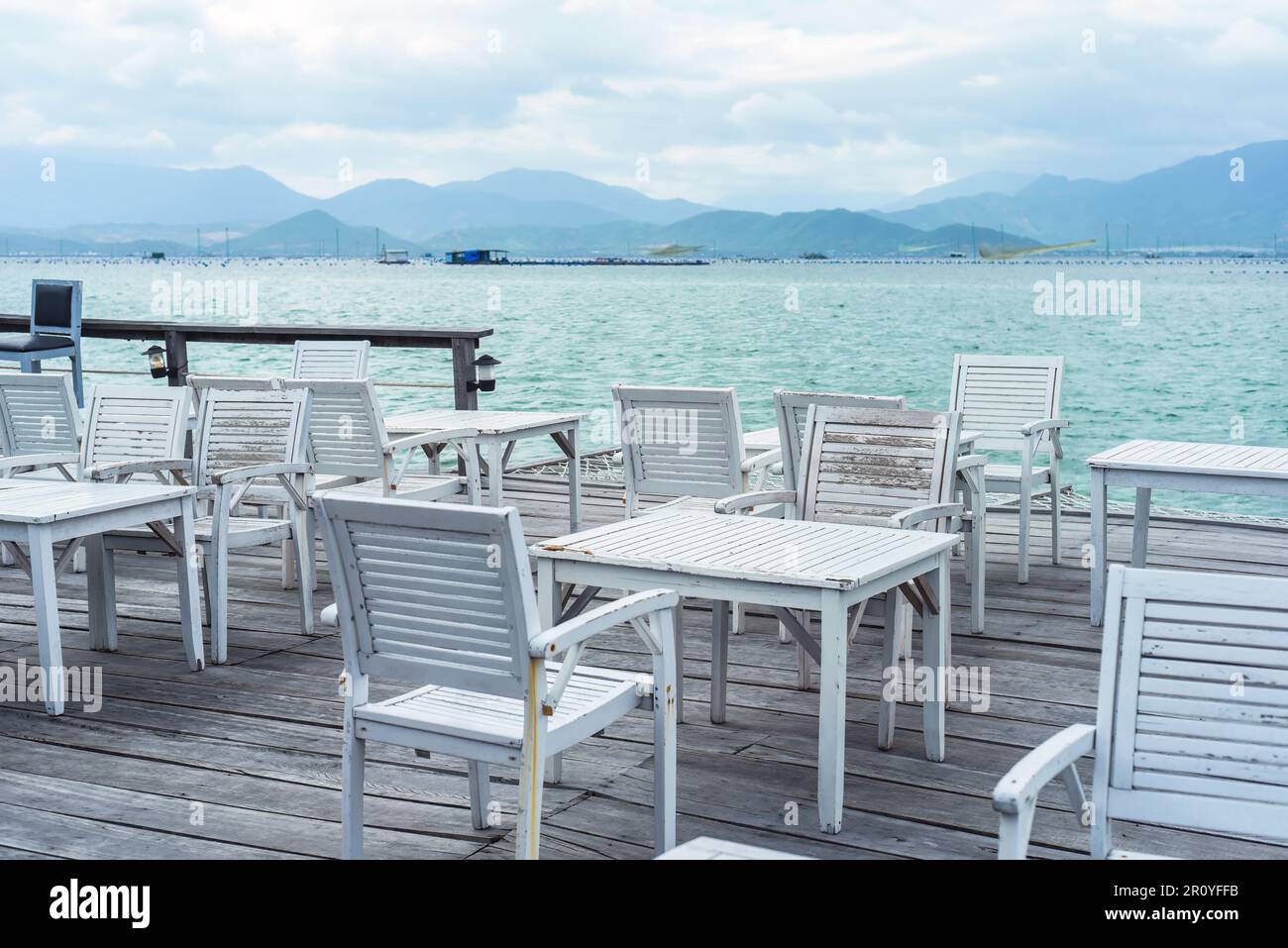 Sedie e tavoli di legno bianco sul molo di legno del sud della cina in Vietnam Foto Stock