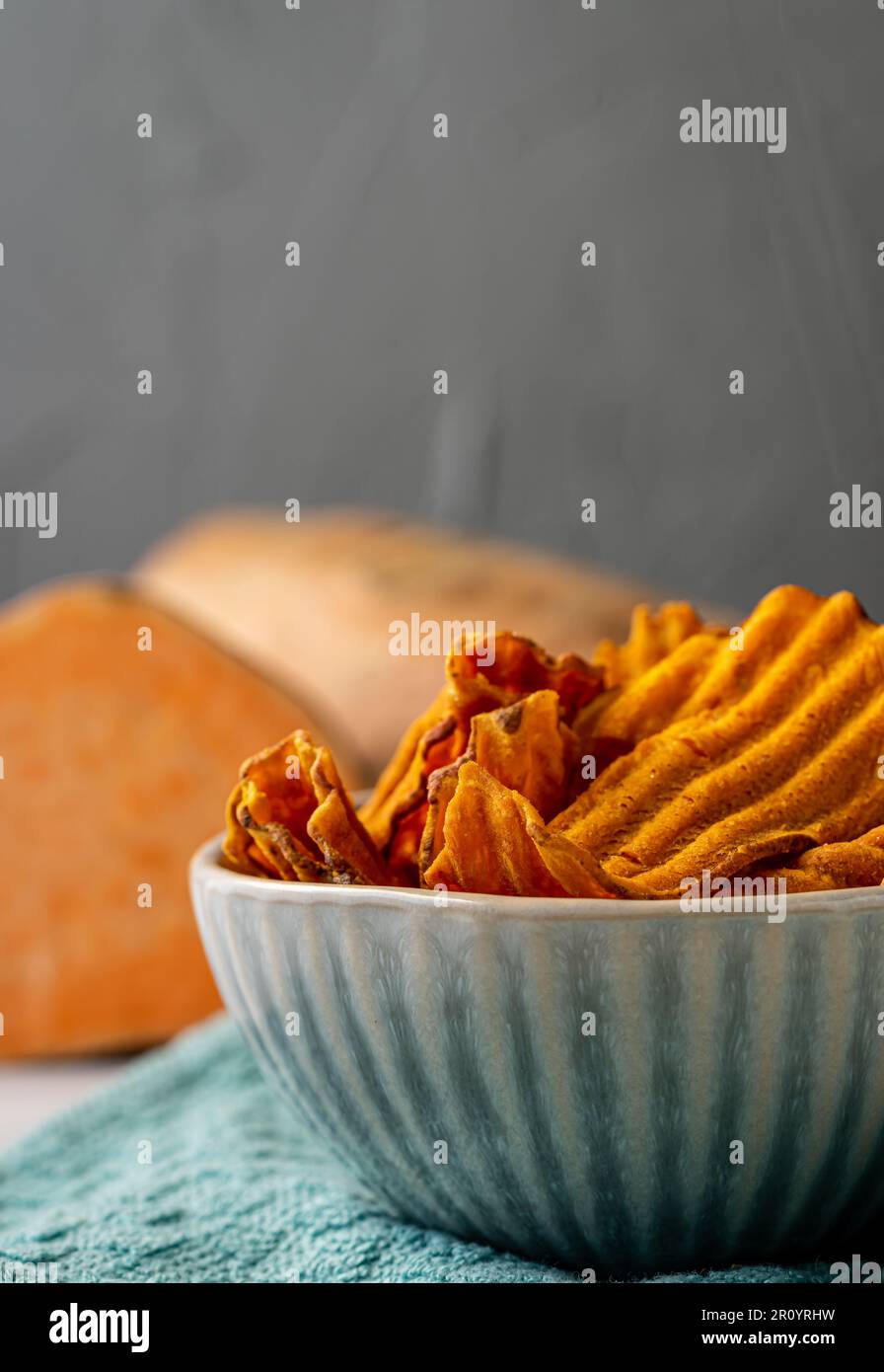 Patatine dolci in una ciotola. Patate dolci sullo sfondo. Foto Stock