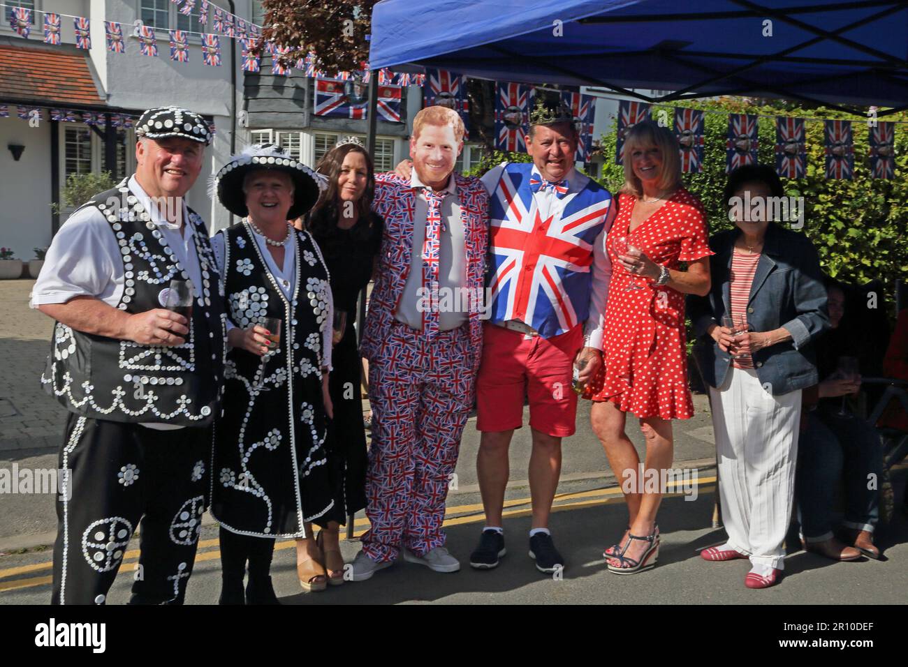 Ritratto di Pearly King e Queen e le persone vestite come Principe Harry e Meghan a Street Party che celebra il re Carlo III incoronazione Surrey Inghilterra Foto Stock