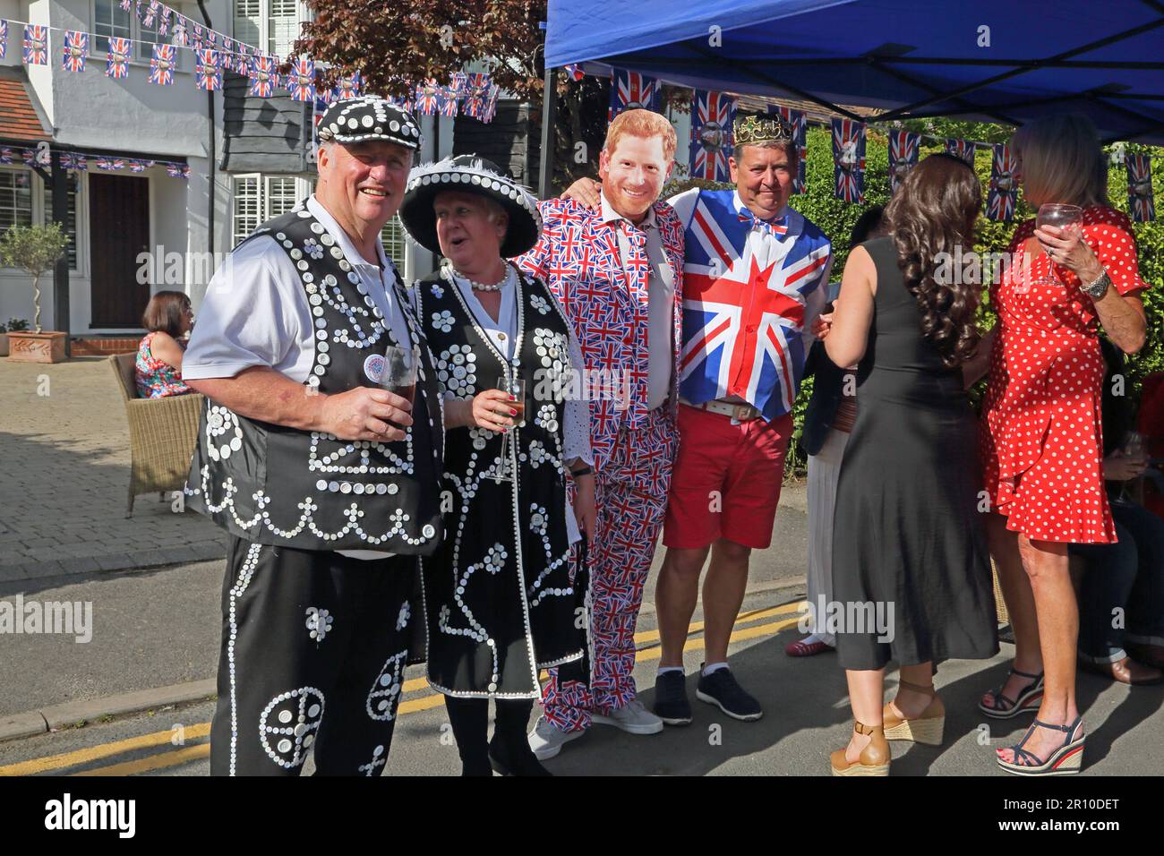 Ritratto di Pearly King e Queen e le persone vestite come Principe Harry e Meghan a Street Party che celebra il re Carlo III incoronazione Surrey Inghilterra Foto Stock