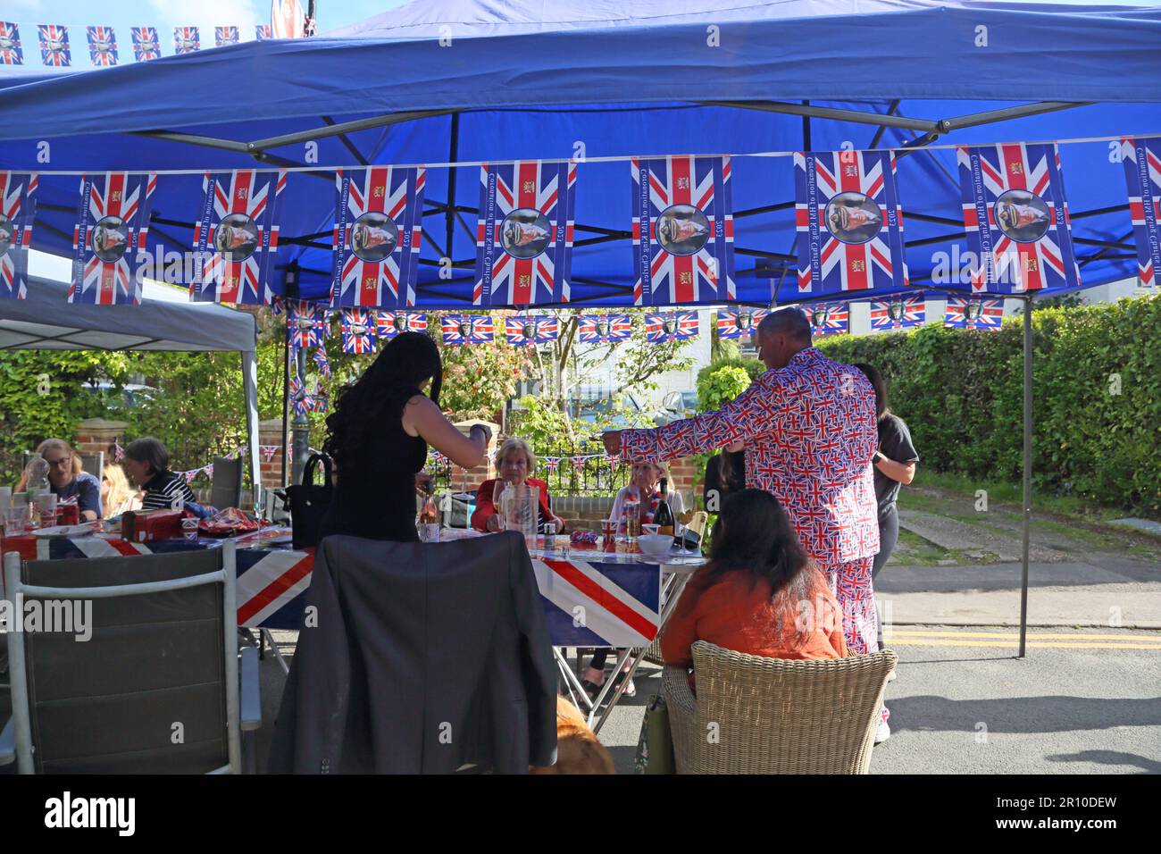 Persone socializzare mangiare e bere a Street Party celebrare re Charles III incoronazione Surrey Inghilterra Foto Stock