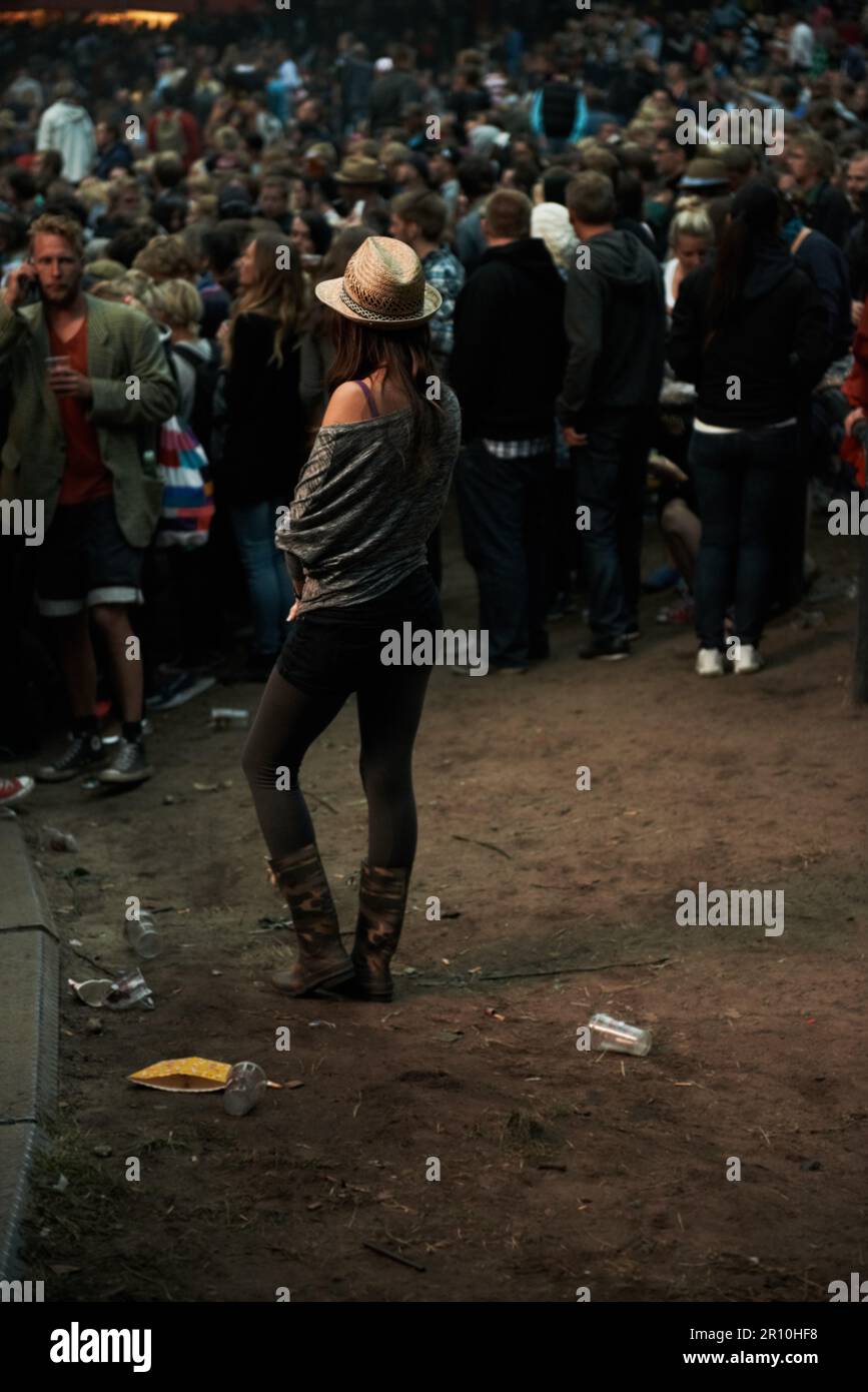 Entrare nell'atmosfera. Tutta la lunghezza di una giovane donna ad un festival di musica godendo le bande da sola. Foto Stock