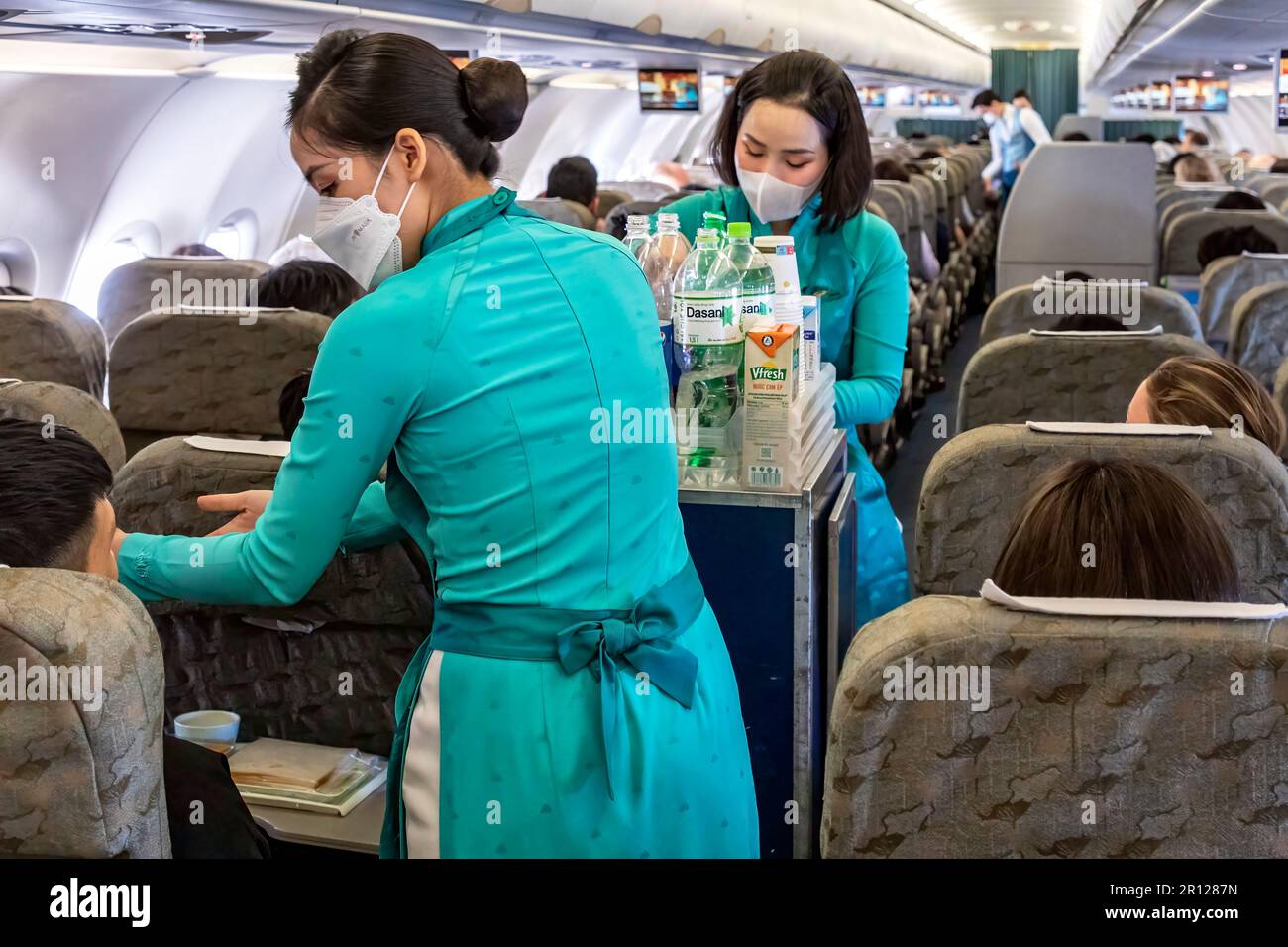 L'equipaggio di cabina della Vietnam Airlines indossa la tradizionale uniforme di ao dai durante il volo Foto Stock