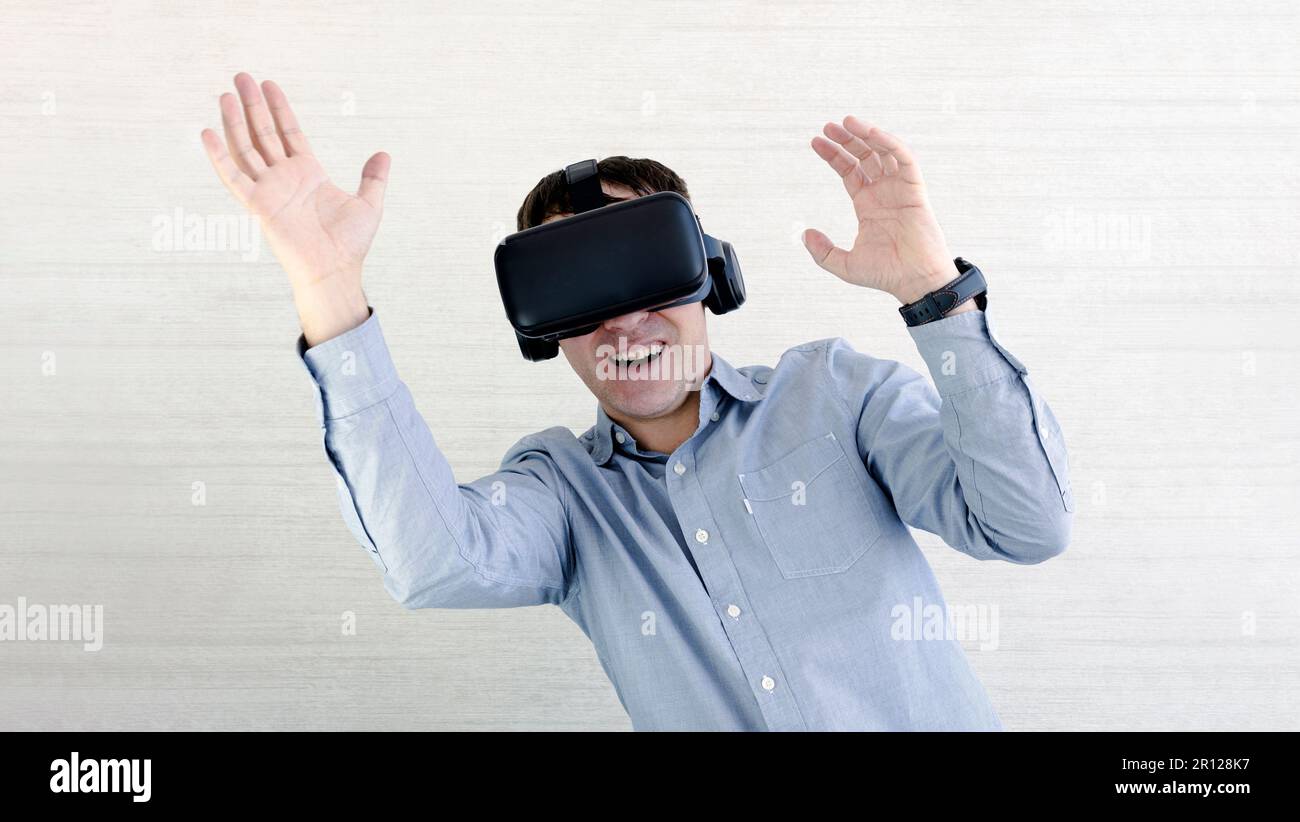 Un uomo felice negli occhiali VR sta urlando. Concetto di emozioni umane, espressione facciale, gadget e tecnologie moderne. La cuffia maschile in 3D sta ballando sulla w Foto Stock