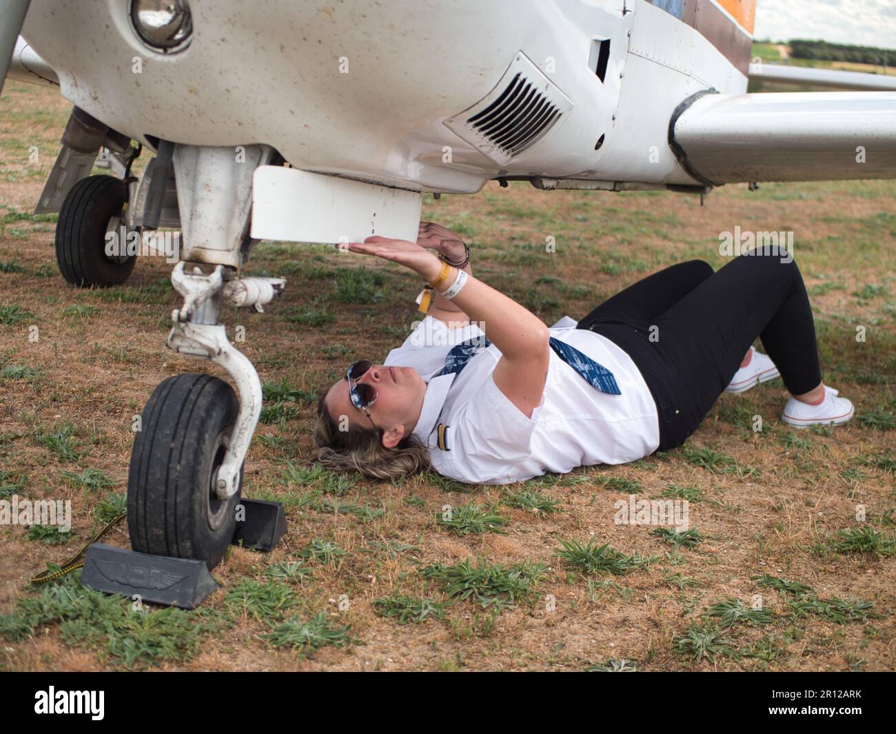 «Una pilota femmina controlla la porta del carrello di atterraggio del suo aereo Foto Stock