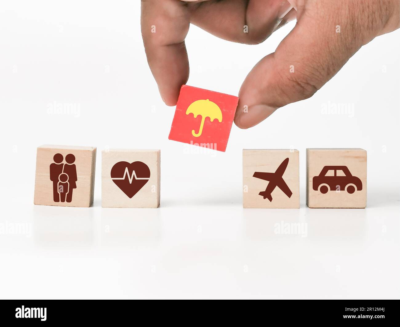 Una persona isolata che organizza con cura una collezione di cubi di legno con immagini variabili stampate su di essi Foto Stock