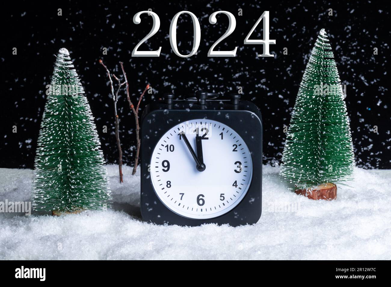 Capodanno 2024. Vigilia di Natale. Composizione Foresta invernale notturna, Blizzard e sveglia nella neve. Inverno. Natale Foto Stock