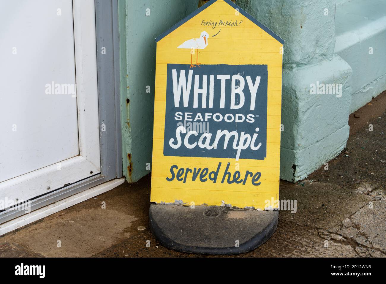 Un cartello all'esterno di un ristorante a Whitby, North Yorkshire, Regno Unito, afferma: "Whitby Seafood scampi served here" Foto Stock