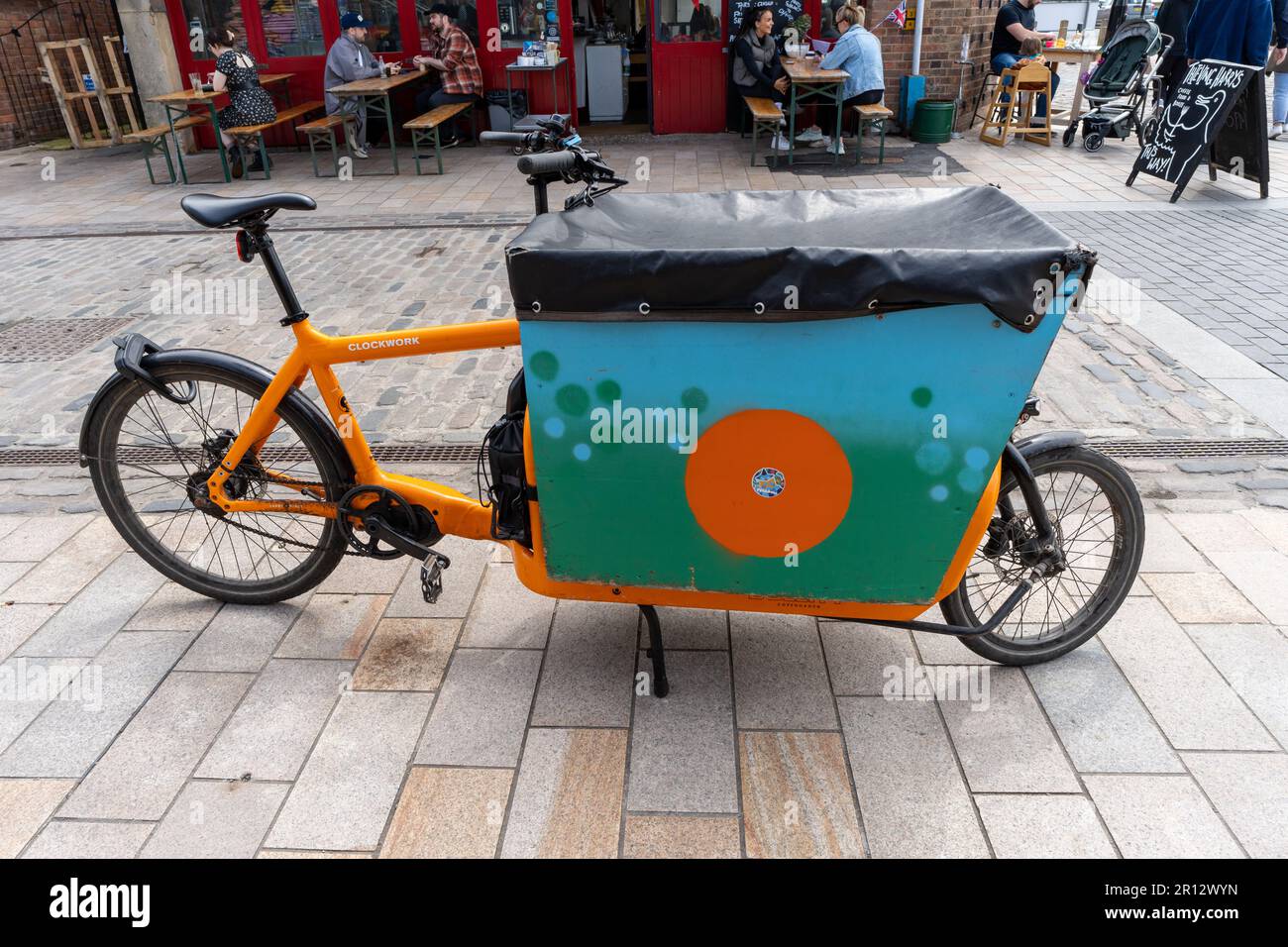 Una bicicletta da carico arancione nella zona del mercato della frutta della città di Kingston upon Hull, Regno Unito. Foto Stock