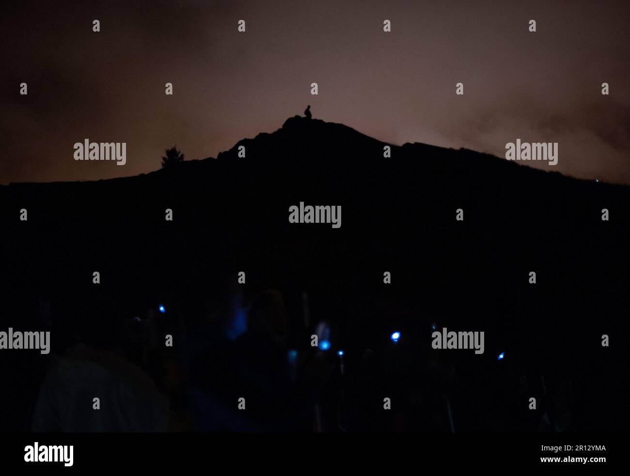 La silhouette di una persona si trova in cima alla Arthurs Seat durante una NVA Speed of Light Production sulla collina di Edimburgo Foto Stock