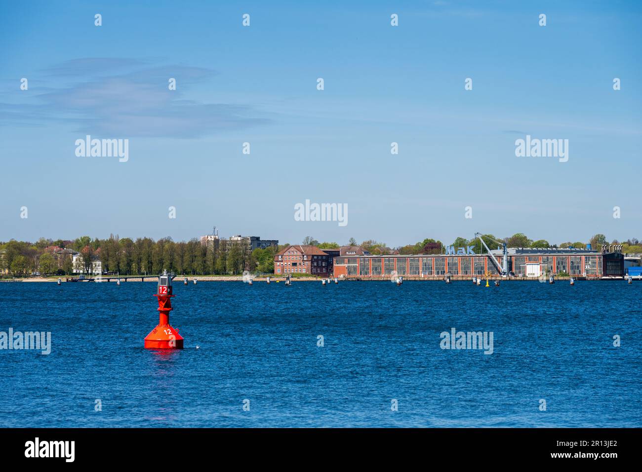 Kiel, Deutschland, mai 2023 Panoramaaufnahme Blick über die Innenförde zu Werft und Industriegebiet in Friedrichsort im Vordergrund eine rote Fahrwass Foto Stock