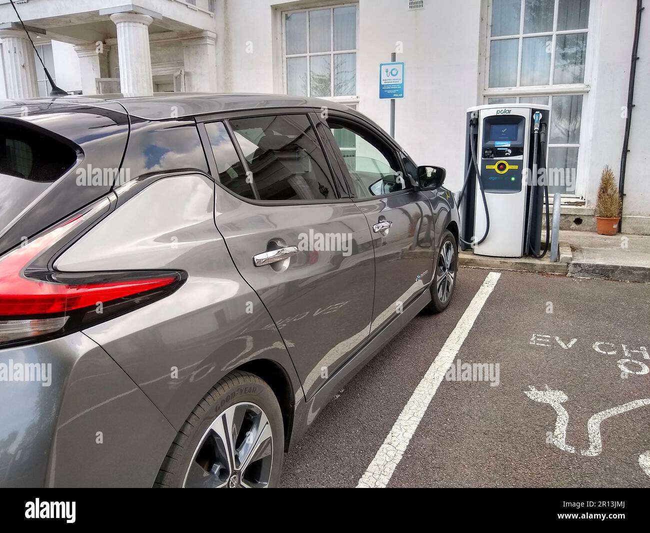 Ricarica di un veicolo elettrico Nissan Leaf presso un caricatore rapido BP Pulse in un parcheggio di hotel a Northam, North Devon, Inghilterra. Foto Stock