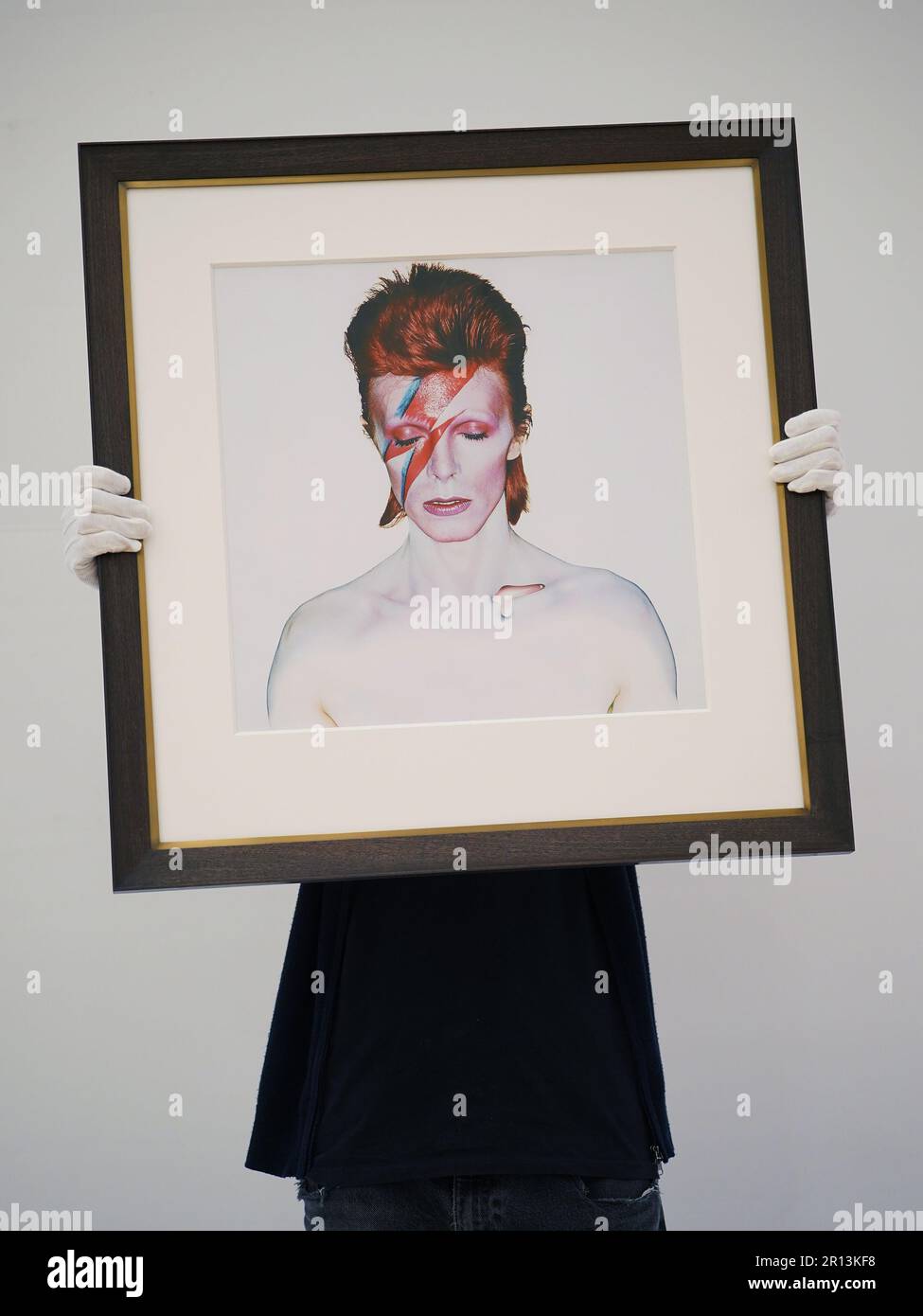Un tecnico della galleria che tiene una fotografia di Brian Duffy, David Bowie, 1973, con una stima di £7.000-9.000, in esposizione a Phillips, Londra, durante una telefonata fotografica per una collezione privata di opere di fotografi del 20th e del 21st secolo, prima che siano offerte per la vendita dalla casa d'asta. Data immagine: Giovedì 11 maggio 2023. Foto Stock