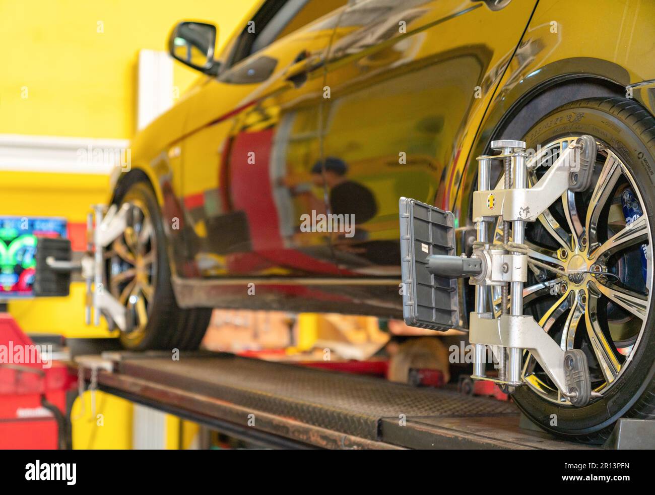 Allineamento ruote ,vettura su supporto con sensori su ruote per controllo campanatura allineamento ruote in officina stazione di servizio. Foto Stock