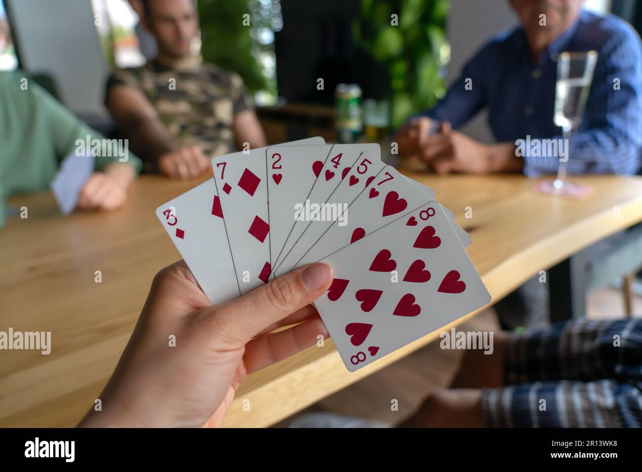 Donna che gioca con le carte con gli amici primo piano . Foto Stock