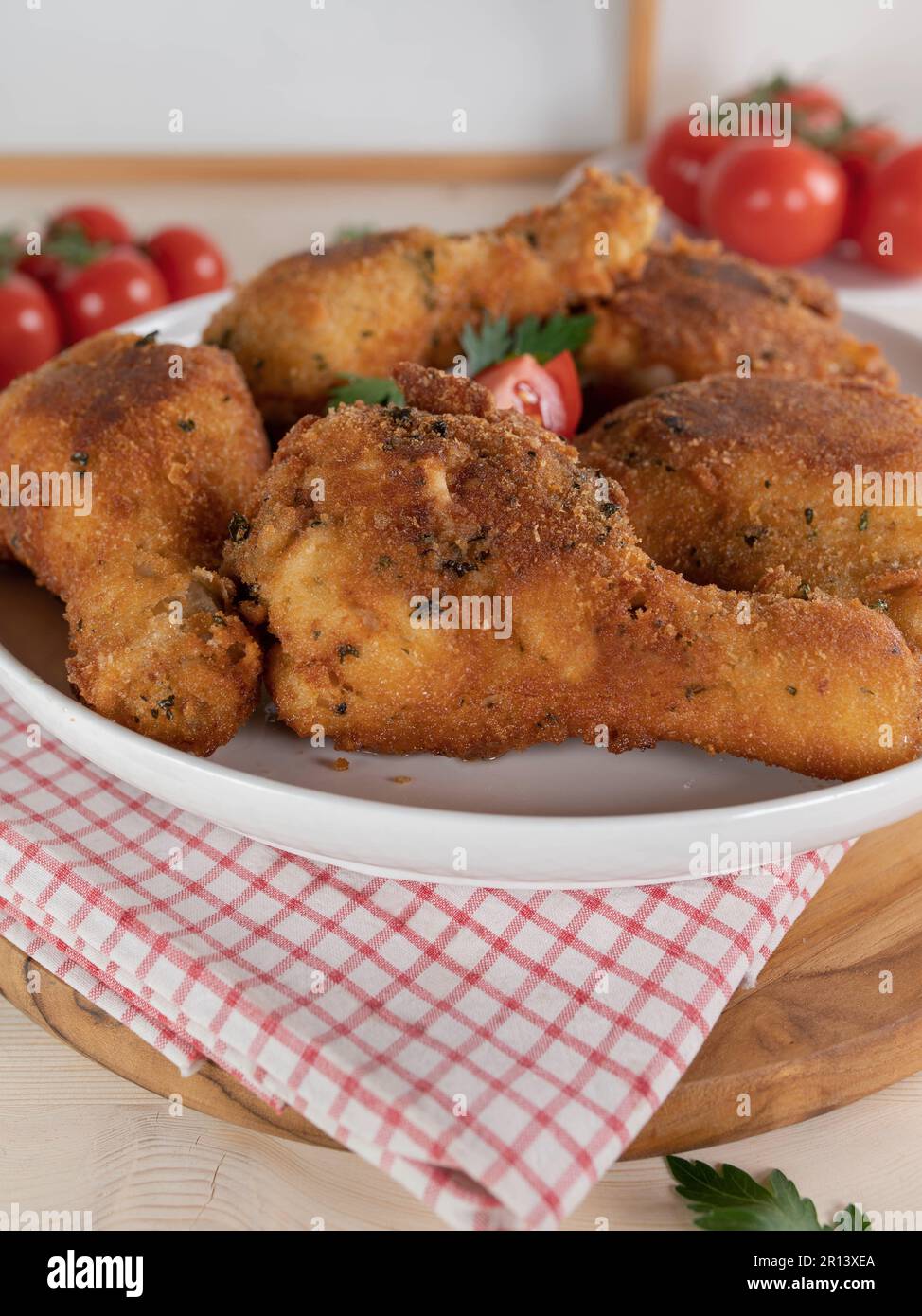 Cosce di pollo impanate al parmigiano e cosce su un piatto Foto Stock