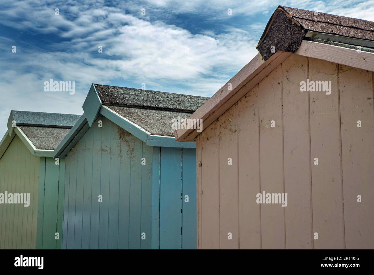 Il retro di tre capanne da spiaggia in tonalità pastello a Buddleigh Salterton, Devon, Inghilterra Foto Stock