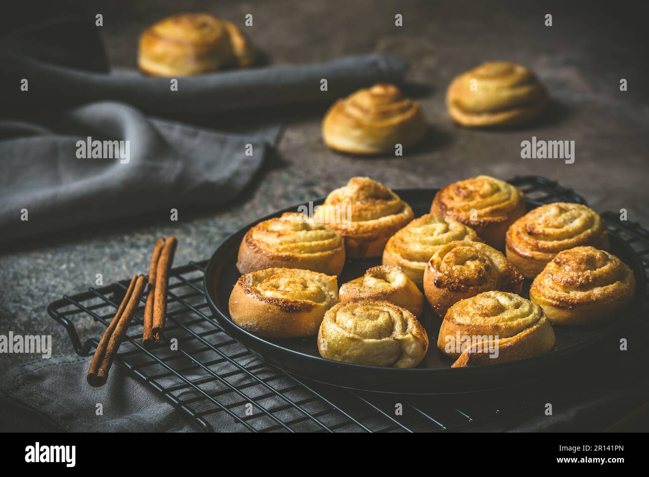 Rotoli di cannella su un tavolo nero su sfondo scuro Foto Stock