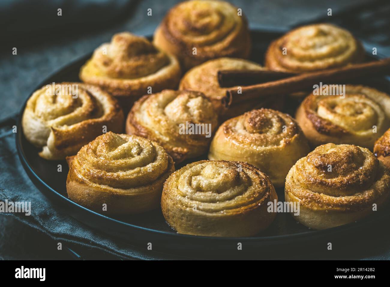 Rotoli di cannella su un tavolo nero su sfondo scuro Foto Stock